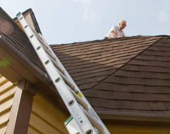 Novato roofing expert inspecting a roof for damage during summer
